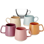Różne filiżanki i kubki: przezroczysta szklana filiżanka BASIC, ceramiczne kubki TAMO w kolorze piaskowym i jasnoniebieskim oraz kolorowe ceramiczne filiżanki NITA (jagodowa, różowa, pomarańczowa).