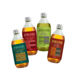 Vier Glasflaschen HIRAMS Tee-Limonaden in verschiedenen Geschmacksrichtungen: Green Tea Mango & Pineapple, White Tea Rose & Pomegranate, Matcha & Maracuja sowie Rooibos & Aloe – mit modernem Etikettendesign.