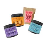 Four colourful tins and a pouch with Hirams superfood blends — Blue Matcha, Purple Ube, Turmeric Golden Dust and Beetroot.